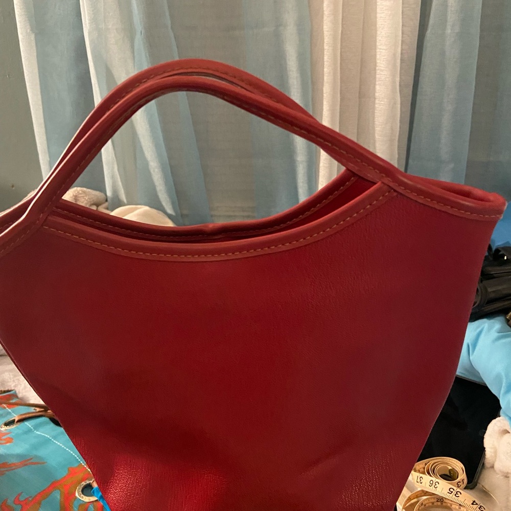 Red hand bag that is adorable.  Made from leather like material.